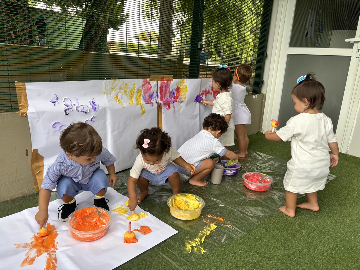 Crianças pintando em grupo ao ar livre