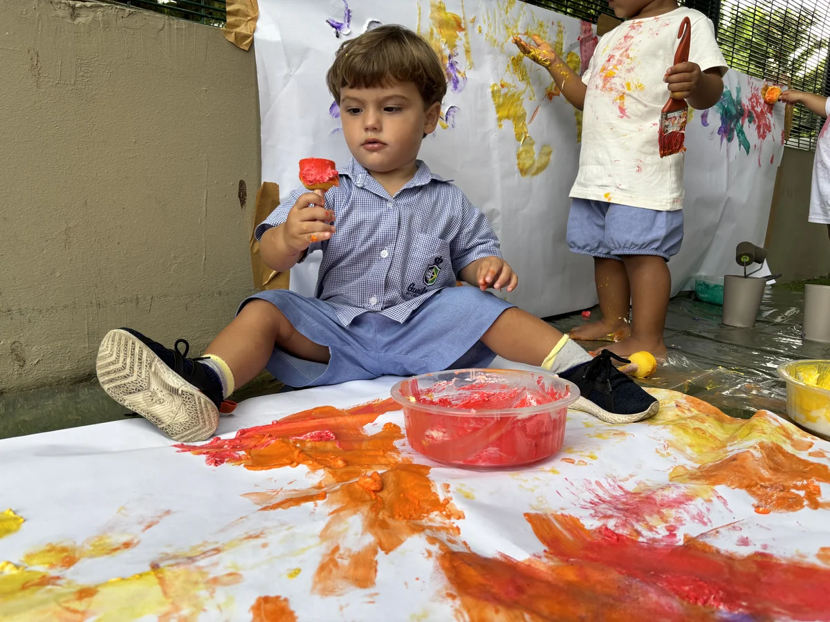 Criança pintando com esponja laranja