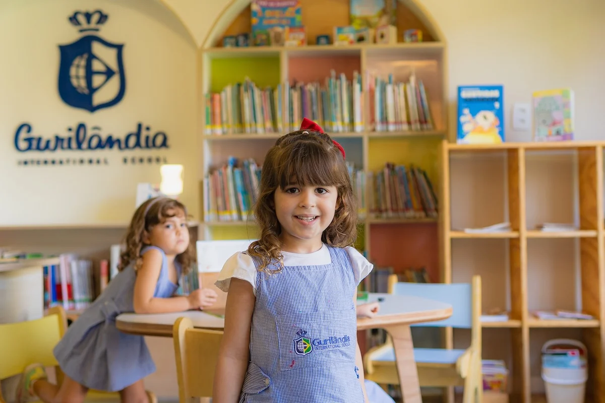 Aluna sorrindo na biblioteca da Gurilândia Federação
